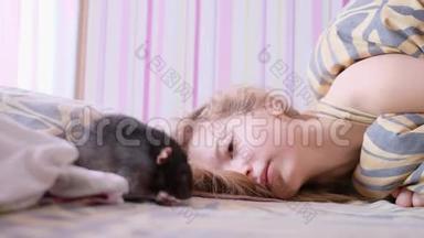家<strong>鼠</strong>走在毯子上。 一个十几岁的<strong>女孩</strong>躺在床上玩老<strong>鼠</strong>。